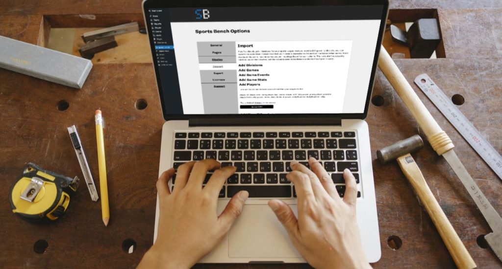 MacBook showing a screenshot of the import data page for Sports Bench in the WordPress admin while sitting on a wooden desk